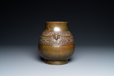 A Chinese bronze 'hu' vase with taotie masks, the base inscribed, 18/19th C.