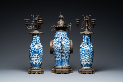 Une garniture de chemin&eacute;e &agrave; pendule en porcelaine de Chine en bleu et blanc mont&eacute;e en bronze, 19&egrave;me