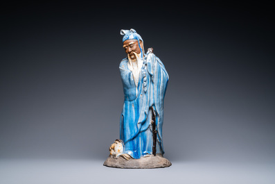 Een grote Chinese blauw-geglazuurde Shiwan aardewerken figuur van een onsterfelijke, 19e eeuw