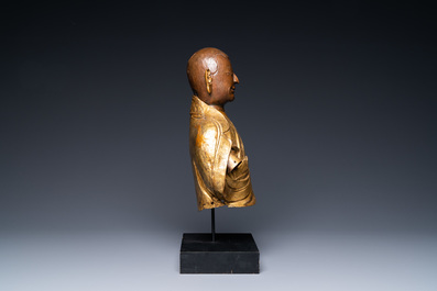 A Tibetan partly gilded brass bust of a Buddhist monk, 18th C.