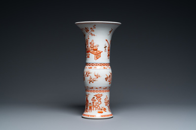 A Chinese iron-red and gilt 'gu' vase with antiquities, Kangxi