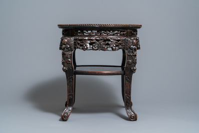 A Chinese carved wooden marble top stand, 19th C.