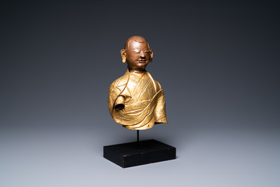 A Tibetan partly gilded brass bust of a Buddhist monk, 18th C.