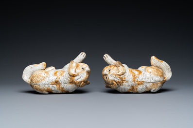 A pair of Chinese porcelain models of reclining dogs, Qianlong/Jiaqing