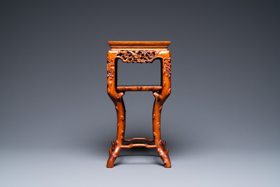 A Chinese carved wooden marble top stand, 19th C.