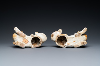 A pair of Chinese porcelain models of reclining dogs, Qianlong/Jiaqing