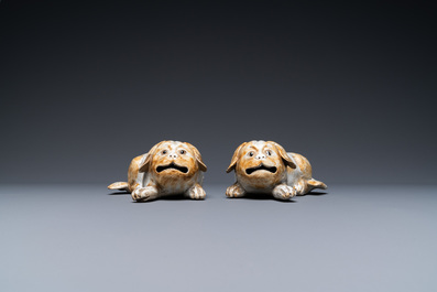 A pair of Chinese porcelain models of reclining dogs, Qianlong/Jiaqing