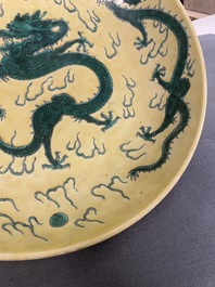Un plat en porcelaine de Chine famille verte &agrave; d&eacute;cor de dragons sur fond jaune, probablement Qianlong