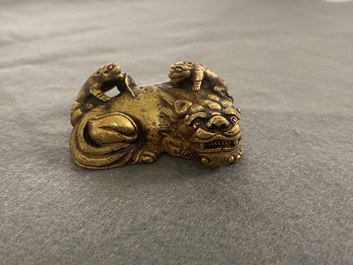 Un poids de rouleau en bronze dor&eacute; en forme de lion et deux lionceaux, Qing