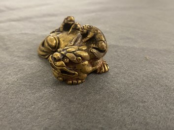 Een Chinees verguld bronzen scrollgewicht met een leeuw met welpjes, Qing