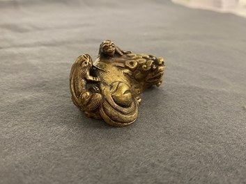 Een Chinees verguld bronzen scrollgewicht met een leeuw met welpjes, Qing