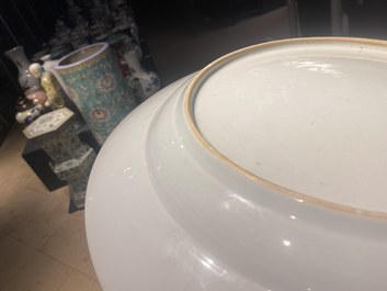 Un grand plat en porcelaine de Chine famille rose &agrave; d&eacute;cor de figures devant un temple, Yongzheng