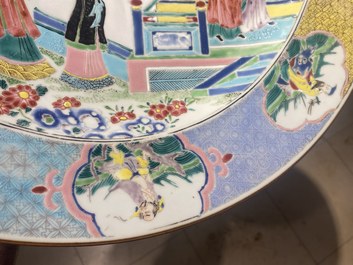 Un grand plat en porcelaine de Chine famille rose &agrave; d&eacute;cor de figures devant un temple, Yongzheng