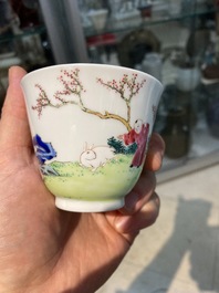 A Chinese famille rose cup and saucer with ladies and a boy playing with a rabbit, Yongzheng