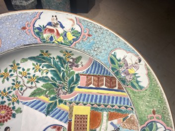 Un grand plat en porcelaine de Chine famille rose &agrave; d&eacute;cor de figures devant un temple, Yongzheng