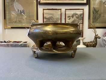 A Chinese bronze tripod censer on stand, Qianlong mark, Qing