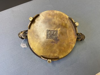 Un grand br&ucirc;le-parfum tripod en bronze aux anses en forme de chilong, Chine, Ming