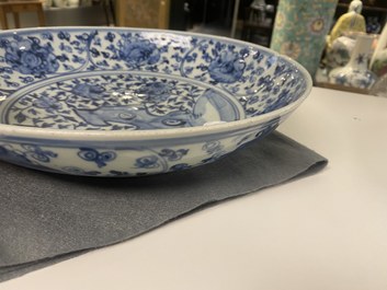 A Chinese blue and white dish with rockwork surrounded by flowers, Ming
