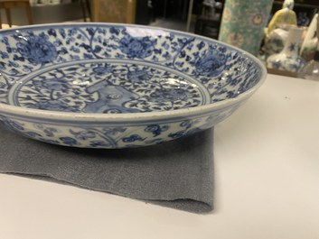 A Chinese blue and white dish with rockwork surrounded by flowers, Ming