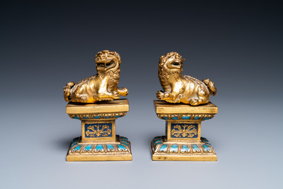 Een paar Chinese vergulde bronzen boeddhistische leeuwen op champlev&eacute; basissen, 18/19e eeuw