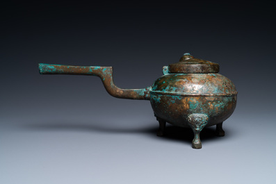 Een Chinese vergulde driepotige bronzen 'he' ketel met een vogelhoofd als tuit, Han