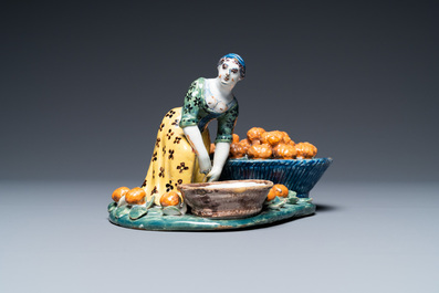 A polychrome Dutch Delft figure of a fruit seller with a small tureen, 18th C.