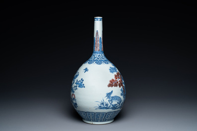 Een Chinese blauw-witte en koperrode flesvormige vaas met een hert en vogels bij bloesemtakken, Daoguang