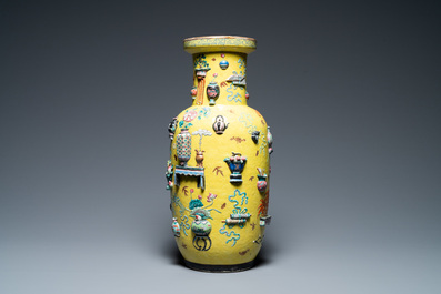 A Chinese yellow-ground famille rose rouleau vase with applied 'antiquities' design, 19th C.