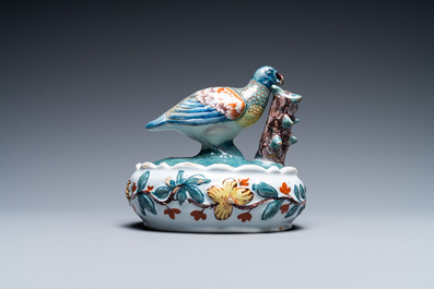 A polychrome Dutch Delft butter tub and cover with a bird, 18th C.