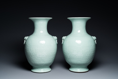 A pair of Chinese monochrome celadon vases with underglaze design on wooden stands, Qianlong mark, 18/19th C.