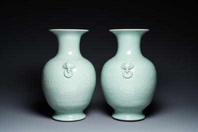 A pair of Chinese monochrome celadon vases with underglaze design on wooden stands, Qianlong mark, 18/19th C.