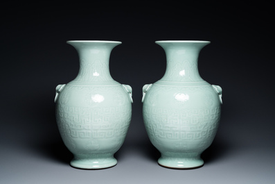 A pair of Chinese monochrome celadon vases with underglaze design on wooden stands, Qianlong mark, 18/19th C.