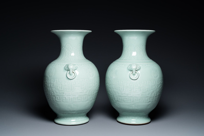 Een paar Chinese monochrome celadon vazen met onderglazuur decor op houten sokkels, Qianlong merk, 18/19e eeuw