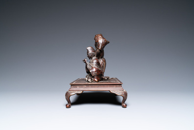 A Japanese bronze okimono depicting two figures on a base, Meiji, 19th C.