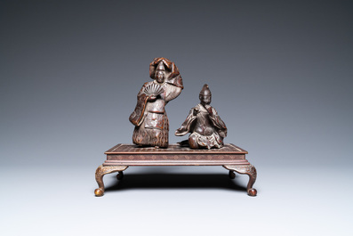 A Japanese bronze okimono depicting two figures on a base, Meiji, 19th C.