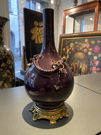 Un vase de forme bouteille en porcelaine de Chine en aubergine monochrome &agrave; monture en bronze dor&eacute;, marque de Qianlong, 19/20&egrave;me