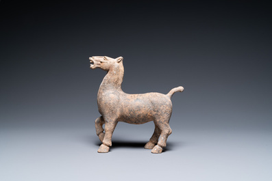 Een Chinees aardewerken model van een stappend paard, Han