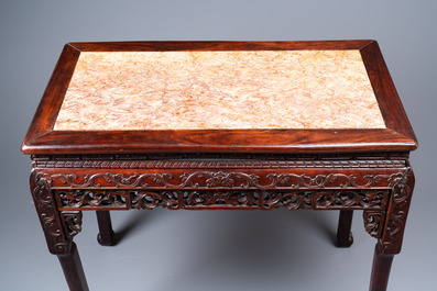 A Chinese rectangular carved wooden table with marble top, 19th C.