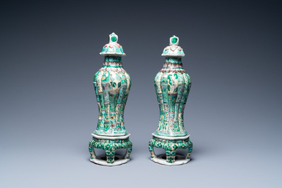 A pair of Chinese verte biscuit vases and covers on stands, Kangxi