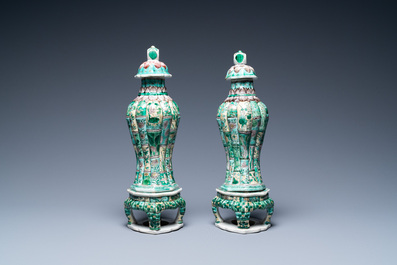 A pair of Chinese verte biscuit vases and covers on stands, Kangxi