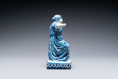A Dutch Delft blue and white figure of a seated lady, 18th C.