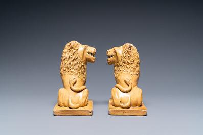 A pair of Flemish or North-French pottery lions, signed and dated 1865