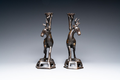 A pair of Chinese bronze deer-shaped candlesticks, Kangxi/Qianlong