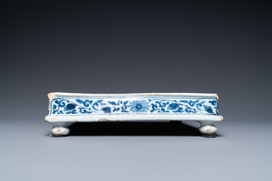A Dutch Delft blue and white square footed tray on ball feet with chinoiserie design, late 17th C.