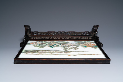 Een Chinese rechthoekige famille rose 'landschaps' plaquette in een houten tafelscherm gevat, 19/20e eeuw