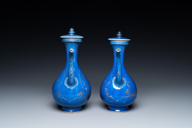 A pair of Chinese gilt-decorated powder blue-ground 'qilin' ewers and covers, Kangxi