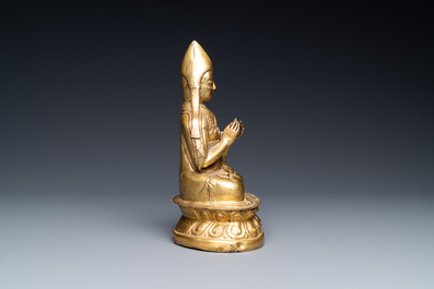 Een Sino-Tibetaanse vergulde bronzen figuur van een lama&iuml;sche hoogwaardigheidsbekleder, wellicht 16e eeuw