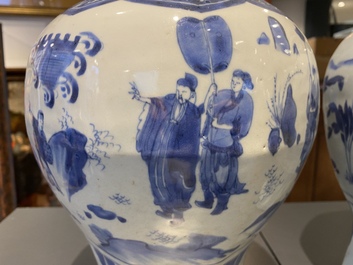 A pair of Chinese blue and white vases and covers with narrative design, Transitional period