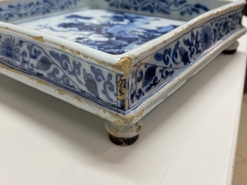 A Dutch Delft blue and white square footed tray on ball feet with chinoiserie design, late 17th C.