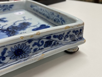 A Dutch Delft blue and white square footed tray on ball feet with chinoiserie design, late 17th C.